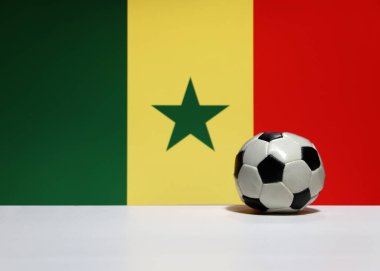 Beyaz zeminde küçük bir futbol topu ve Senegal ulusu bayrakları yeşil, sarı ve kırmızı renklerde. Spor konsepti.