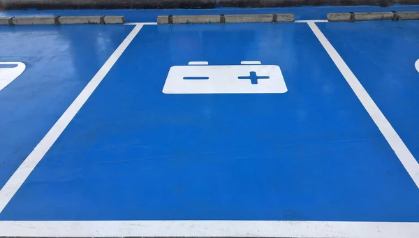 蓝色停车场和白色标志的电池在地板上 停车场服务的汽车修理或更换电池 — 图库照片
