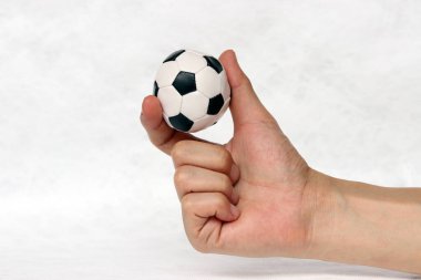 Mini futbol topu elinde, beyaz arka planda iki parmağınla tut. Spor kavramı ya da ele alınan oyun ya da küçük mesele.
