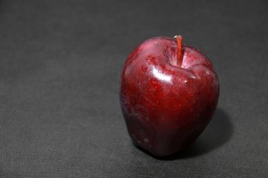 Siyah zeminde koyu kırmızı elma. Gül familyasından bir ağacın yuvarlak meyvesidir ve tipik olarak çıtır çıtır eti vardır. Tatlı ya da meyve pişirmek ya da elma suyu yapmak için birçok çeşidi geliştirilmiştir..