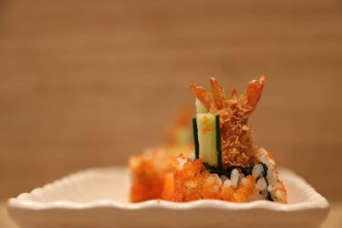 Kızarmış karides tarifi suşi yumurta karidesinde beyaz dikdörtgen tabakta ahşap zeminde..