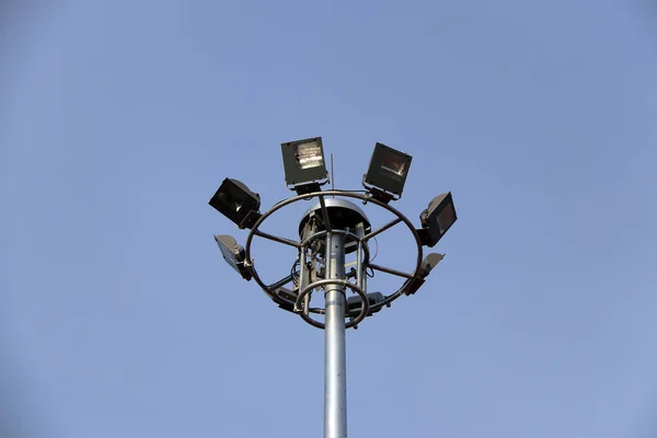 青空を背景に1つのポストに多くの街灯が設置を取り囲みます 道路やスポーツ競技場に使用されます — ストック写真
