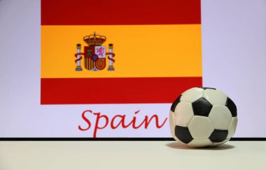 Beyaz zeminde küçük bir futbol topu ve İspanya arka planında İspanyol bayrağı. Spor konsepti, İspanya dünyadaki futbol turnuvasının finalistlerinden biridir..