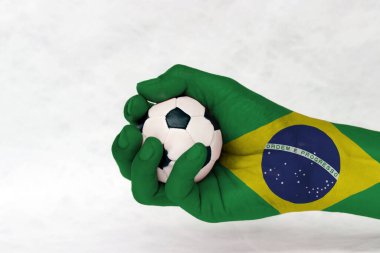 Brezilya 'da küçük bir futbol topu beyaz arka plana el boyanmış. Spor anlayışı ya da ele alınan oyun ya da küçük bir mesele. yeşil sarı ve mavi renk ve dünya ortada.