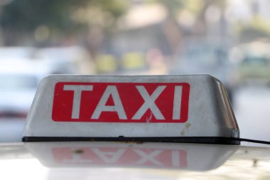 Myanmar, caddenin çatısındaki beyaz yazıyla donuk beyaz ve kırmızı renkli taksi tabelası ya da taksi tabelası bulanık arka planda..