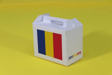 Beyaz barkodlu beyaz kutuda Romanya bayrağı ve sarı arka planda ulus bayrağı. Romanya 'dan ihracat ticareti kavramı, ürünler için kağıt ambalajlama.