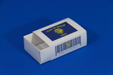 Beyaz barkodlu Oregon bayrağı mavi arka planda eyalet bayrağı rengi eşleşme ya da ürün için kağıt ambalajı. Oregon 'dan ihracat ticareti kavramı.