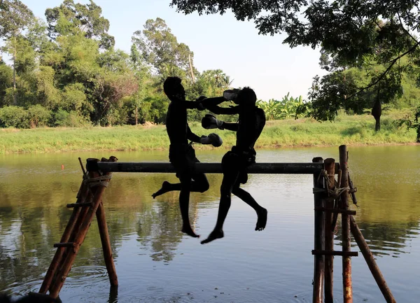 Khai Bang Rachan Sing Buri Thailand 2018年4月14日 シルエットまたは水の上の木材の上の2人の男ボクシングの暗い形と輪郭 それは水の上の伝統的な水タイボクシング またはムエタレー — ストック写真