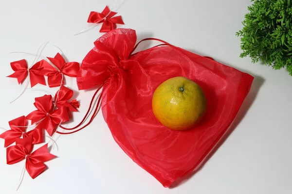 Orange Red Fabric Bag Red Ribbon Green Leaf White Floor — Stock Photo, Image
