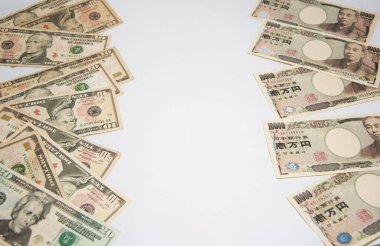 Para değişimi konsepti, solda Amerikan banknotları yığını ve sağda beyaz arka planlı Japon banknotları yığını..