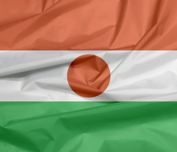 ニジェールのファブリックフラグ ナイジェリアの国旗の背景 オレンジ色の白と緑のクレープ 中央にオレンジ色の丸で帯電 — ストック写真