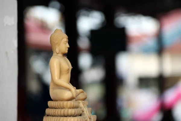 Obok Beżowej Żywicy Posągu Buddyjskiego Wyrzeźbiona Figurka Buddy — Zdjęcie stockowe