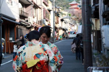 Fushimi-ku, Kyoto, Japonya, 17 Kasım 2017: Kimono elbiseli iki kadın Kyoto 'daki Fushimi Inari Tapınağı' na giderken tapınak veya tapınakta milli üniforma giyecekler. Kimono uzun, geniş kollu ve kravatlı bir bornoz.