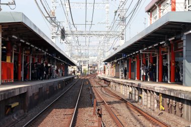 Fushimi-ku, Kyoto, Japonya, 17 Kasım 2017: İnari istasyonunda tren bekleyen yolcuların bulunduğu tren rayları Keihan Ana Hattı tarafından işletiliyor..