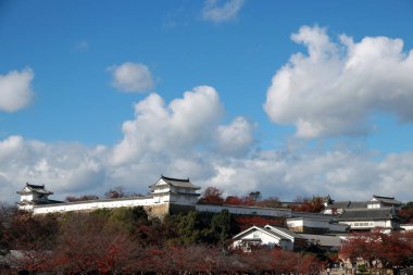 Himeji, Hyogo, Kansai, Japonya, 19 Kasım 2017: Himeji Kalesi 'ndeki binanın bir parçası, kırmızı sonbahar ağacı ve mavi gökyüzü arka planıyla dışarıdan bakıyor. Himeji Kalesi aynı zamanda Beyaz Balıkçıl Kalesi (Shirasagijo) olarak da bilinir.