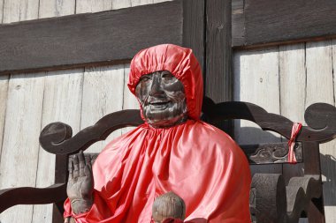 Zoshicho, Nara, Japonya, 21 Kasım 2017: Yakushi Nyorai 'nin kırmızı başlıklı ahşap Buda heykeli, ana bina ve Budist kilisesi Daibutsuden' in girişinde tıp ve sağlık Buda heykeli.