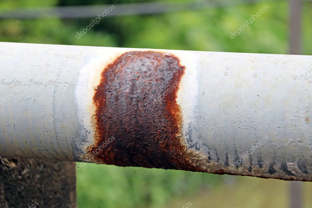 Antique rust Water pipes for village hydrant water on green background. A pipe for conveying water supply community.