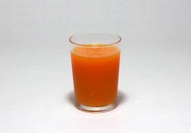 Beyaz arka planda izole edilmiş portakal suyu. Bir bardak meyve suyu, portakaldan elde edilen sıvı..