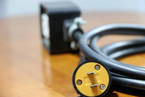 Sarı Fiş Odağın Dışında Ahşap Zeminde Siyah Kablo Var Elektrik — Stok fotoğraf