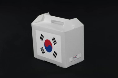 Barkodlu beyaz kutuda Güney Kore bayrağı ve siyah arka planda ulus bayrağı. Güney Kore 'den ihracat ticareti kavramı, kağıt ambalaj ürünleri.