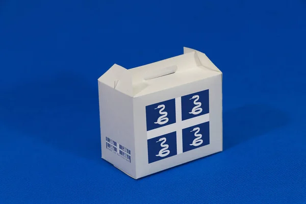 带有条形码的白色盒子上的马提尼克旗和蓝色背景上的国旗的颜色 马提尼克岛出口贸易的概念 产品的纸包装 — 图库照片