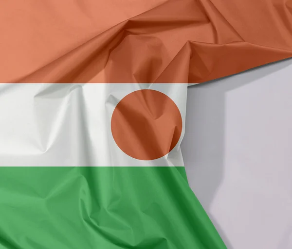 ニジェールの生地の旗クレープと白空間 オレンジ白と緑の増加 中心部にオレンジの円で充電 — ストック写真
