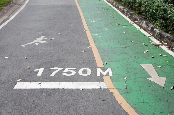 绿色自行车道和白色箭头与慢跑车道和白色慢跑者绘画平行 在1750米远的地方 — 图库照片