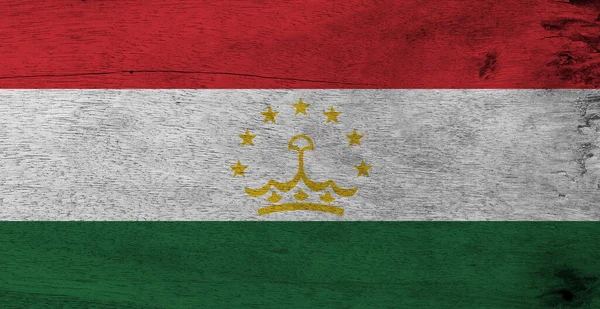 木製の板の背景にタジキスタンの国旗 タジクの旗の質感 赤白と緑を接ぎ木し 中央に7つの星の円弧によって重ねられた冠で充電 — ストック写真