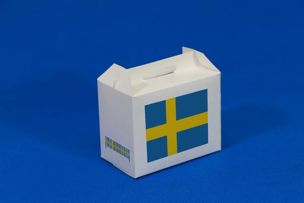 白盒上的瑞典国旗 有条形码 蓝色背景上有国旗的颜色 瑞典出口贸易的概念 产品的纸包装 — 图库照片