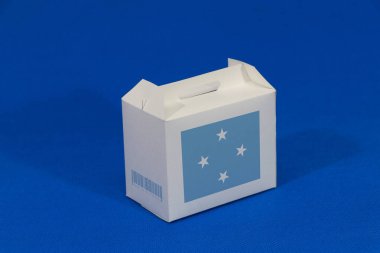 Barkodlu beyaz kutuda mikronezya bayrağı ve mavi arka planda ulus bayrağı. Federasyon Mikronezya Eyaletlerinden ihracat ticareti kavramı, ürünler için kağıt ambalajlama.