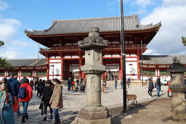 奈良県奈良市雑司町2017年11月21日 東大寺2番目の古美術品木造アーチ入口前の石灯籠と青空を背景に緑の木を持つ多くの観光客 — ストック写真