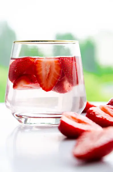 赤生の新鮮なイチゴをグラスで近くで眺めながら飲む — ストック写真