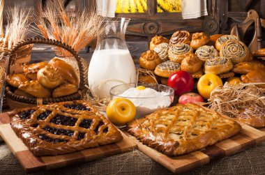 Ev yapımı fırın ürünleri ve mutfakta süt ve elma dolu sürahi, yemek pişirme konsepti. 