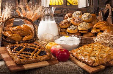 Ev yapımı fırın ürünleri ve mutfakta süt ve elma dolu sürahi, yemek pişirme konsepti. 