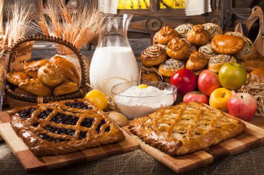 Ev yapımı fırın ürünleri ve mutfakta süt ve elma dolu sürahi, yemek pişirme konsepti. 