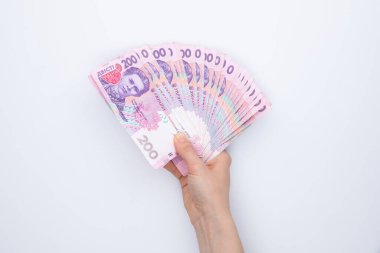 Beyaz arka planda izole edilmiş dişi eliyle Hryvnia banknotları koleksiyonu, yakın görünüm