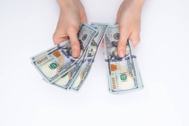 Beyaz arka planda izole edilmiş dolar banknotları sayan kadın elleri, yakın görüş