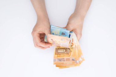 Avro sayan kadın elleri beyaz arka planda izole edilmiş banknotlar, yakın görünüm
