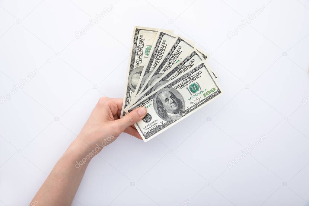 collection of hundred-dollar banknotes in female hand isolated on white background, close view