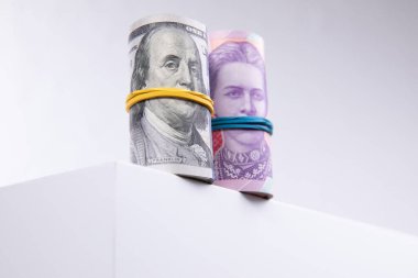 Beyaz arka planda izole edilmiş dolar ve hryvnias ruloları, yakın görüş
