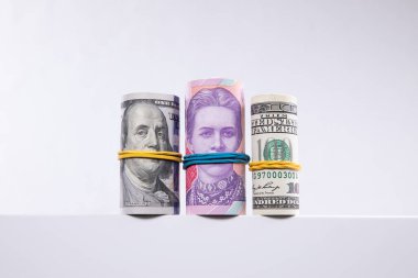 Beyaz arka planda izole edilmiş dolar ve hryvnias ruloları, yakın görüş