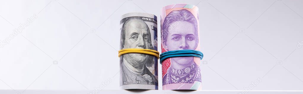 rolls of dollars and hryvnias isolated on white background, close view