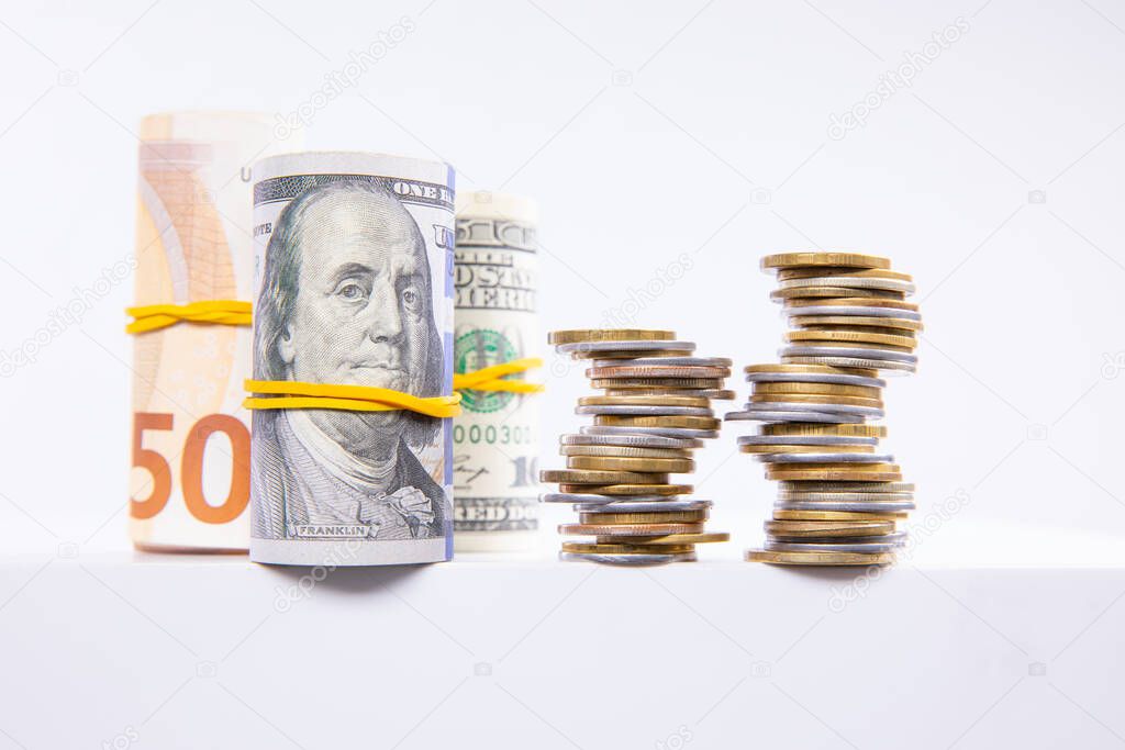 rolls with euro and dollars banknotes with colorful metal coins isolated on white background, close view  