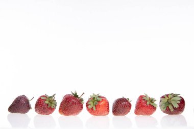 Beyaz arkaplanda kırmızı çiğ çilek, yakın görüş. 