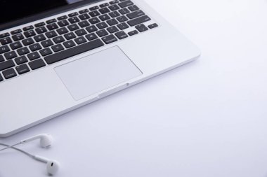 Kulaklıkları beyaz arkaplanda izole edilmiş yeni modern dizüstü bilgisayar klavyesi, yakın görünüm 