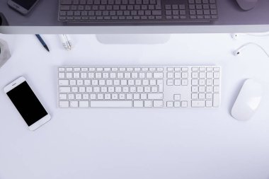 Beyaz arkaplanda izole akıllı telefona sahip bilgisayar faresi ve boş ekran ile yeni modern klavye, yakın görünüm 