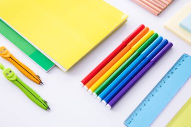 açık arkaplanda parlak renkli kırtasiye koleksiyonu, yakın görünüm  