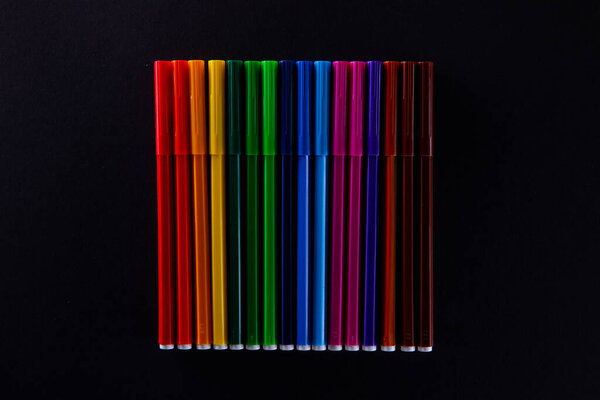 collection of colorful felt-tip pens on dark background, close view 