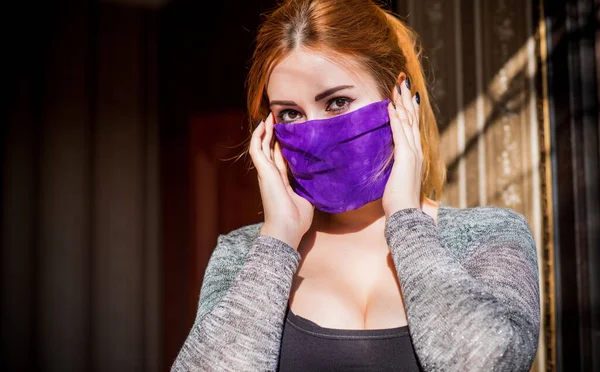Young woman in fashionable homemade mask, scarf on her face, stop virus, save yourself