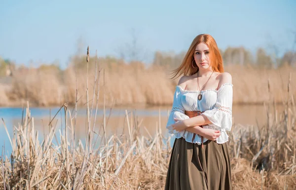 Nature look, Medieval style of clothes, redhead woman in cotton vintage blouse, belt and skirt